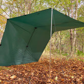 DD Superlight Tarp XL set up in a forest, providing shelter over fallen leaves and trees.